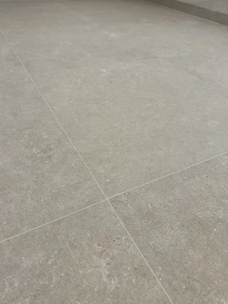 Storformatigt golv i granitkeramik med ljusgrå stenlook och smala fogar