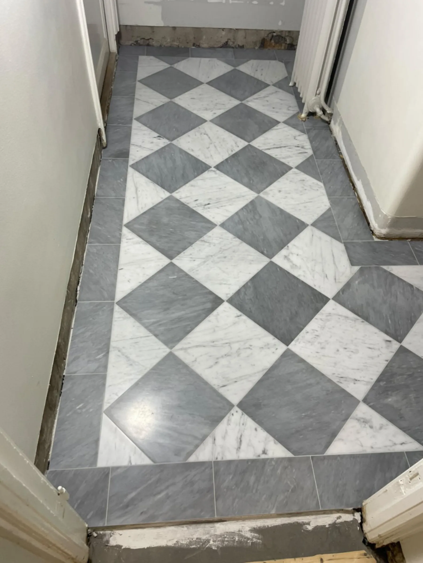Marmorgolv i hall med schackmönster i vit och grå Carrara med ramverk