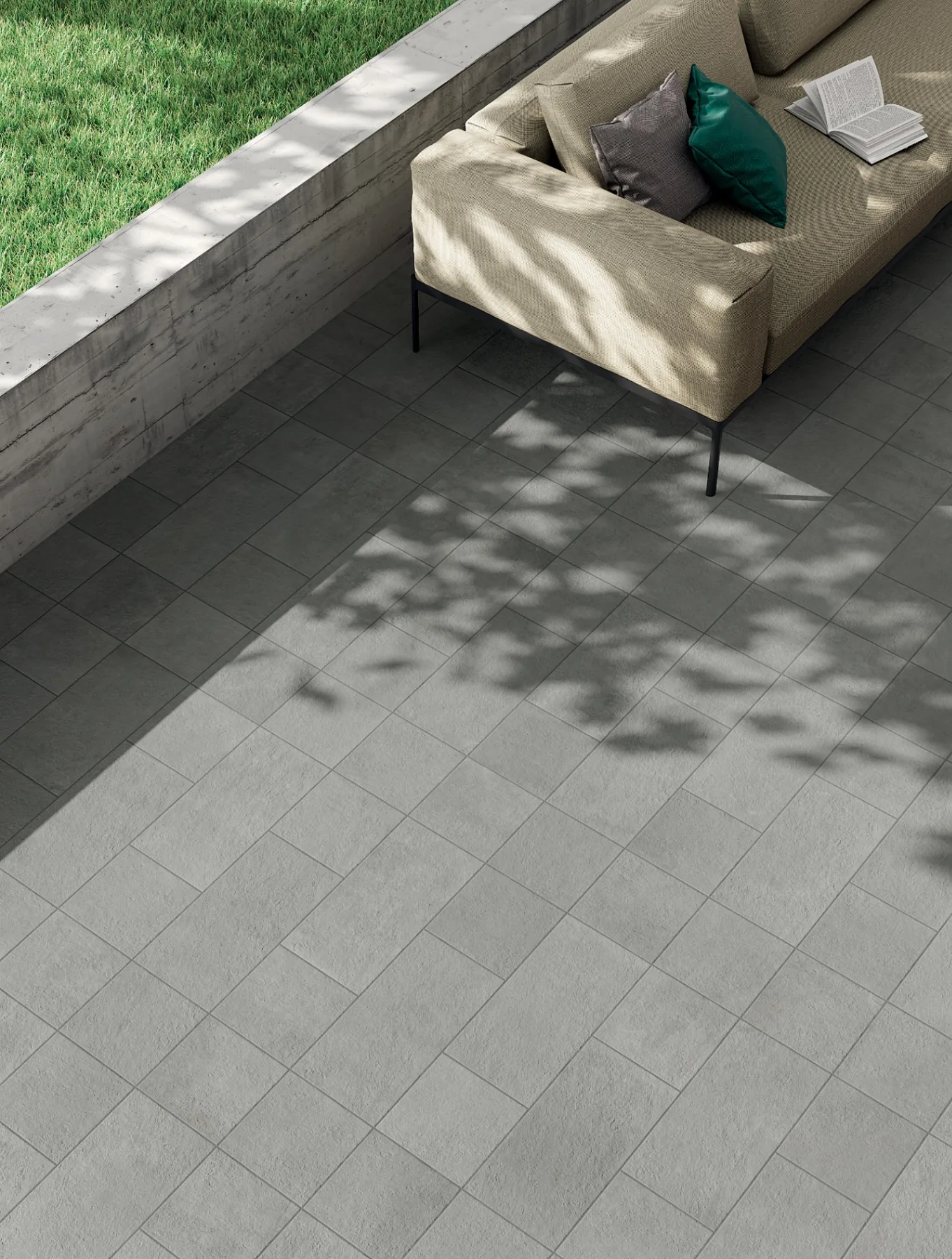 Grågrön granitkeramik 20 mm på terrass med loungemöbler och betongmur