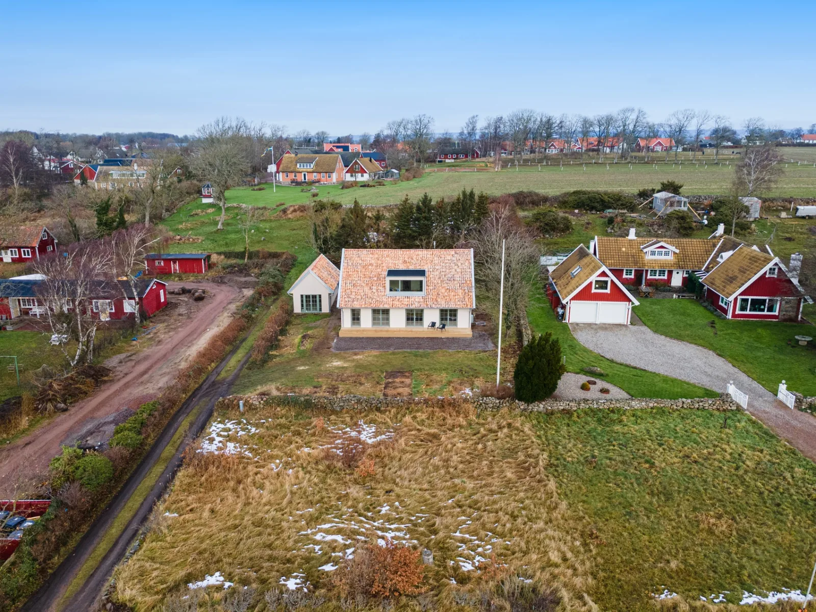 Drönarbild över villa med italienskt taktegel på skånsk landsbygd